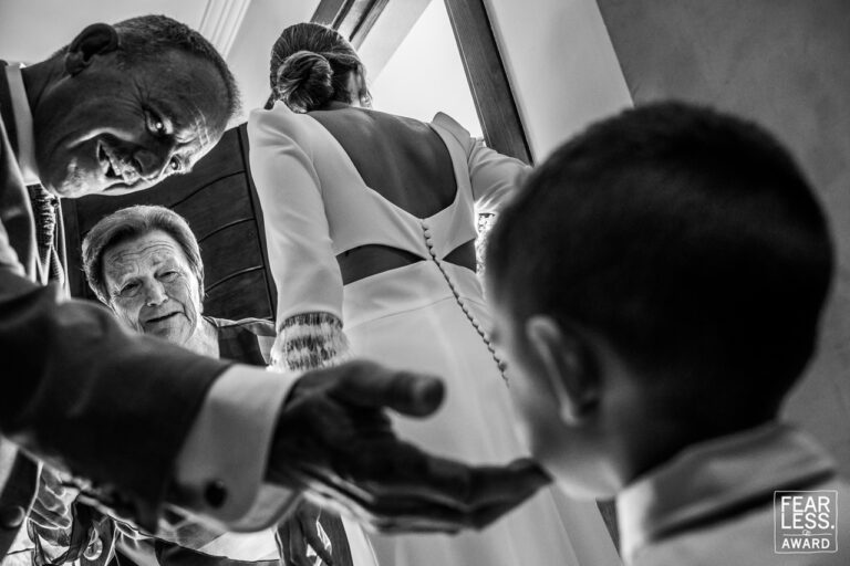 Fotógrafo de bodas natural y sin posados | Adolf Boluda 4 Cuatro generaciones juntas: la novia recibe en la puerta a su padre y su abuela, que acarician con cariño a su nieto. Foto premiada con un Fearless Award.