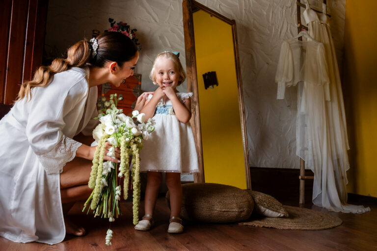 Fotógrafo de bodas natural y sin posados | Adolf Boluda 12 La novia recibe con alegría a su sobrina pequeña durante los preparativos en Villa Mediterráneo, Almoines (La Safor, Valencia).